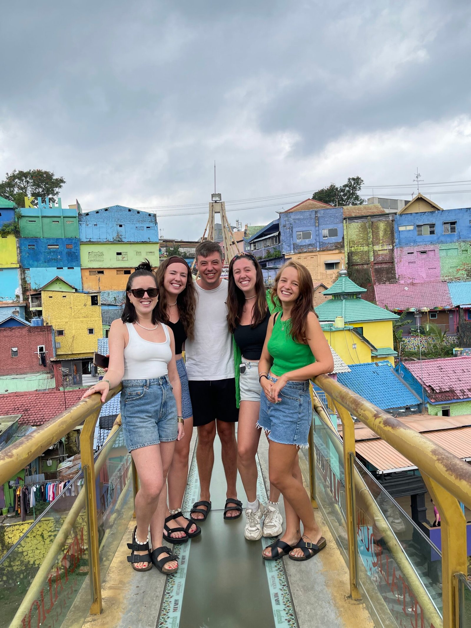 Travelers on the glass bridge in colorful Jodipan village, Malang