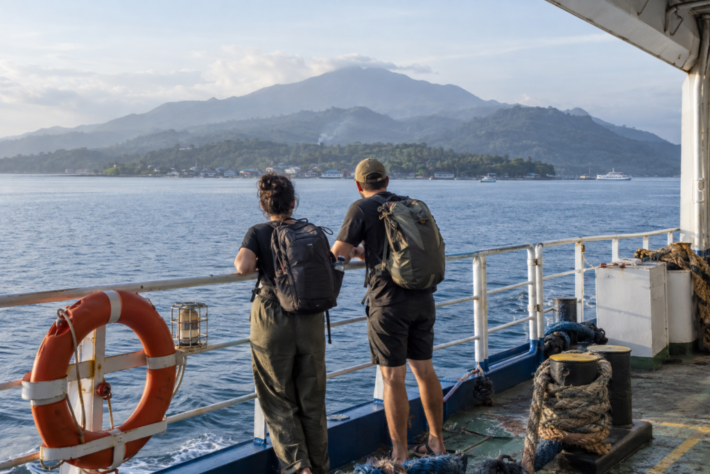 Travelers crossing Indonesian waters by ferry toward a distant island